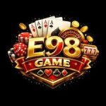 E98 Game official logo with playing cards, dice, casino chips, gold coins, and roulette wheel on a red and gold shield badge