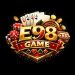E98 Game official logo with playing cards, dice, casino chips, gold coins, and roulette wheel on a red and gold shield badge